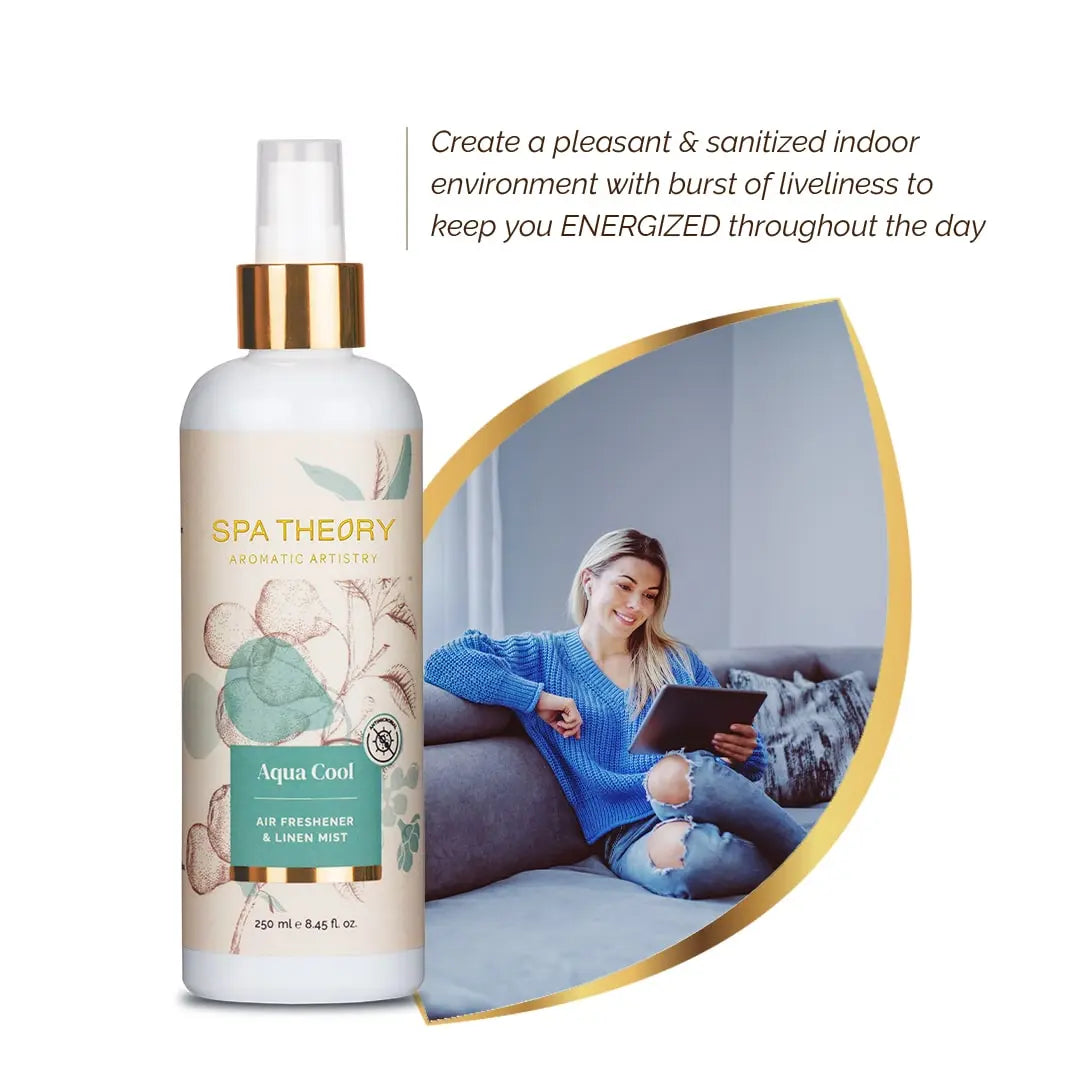 Bottle of Spa Theory Aqua Cool air freshener with botanical design next to a smiling woman in a blue sweater, using a tablet on a couch.
