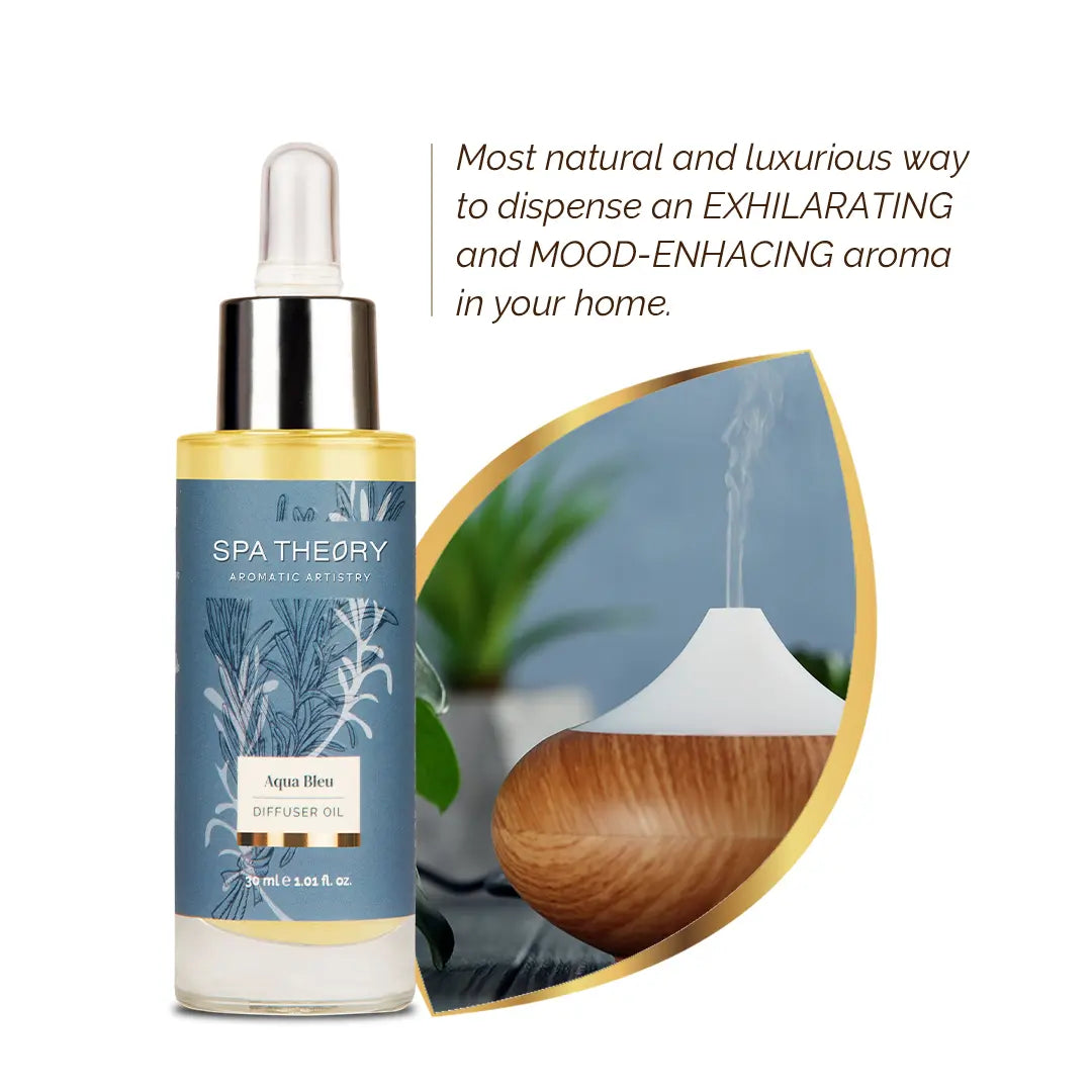 A bottle of Spa Theory diffuser oil labeled "Aqua Bleu" with a dropper top, next to a wooden diffuser emitting vapor