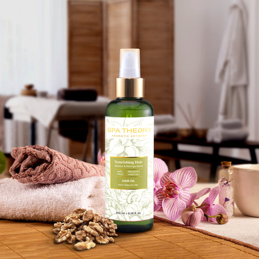 Bottle of Spa Therapy walnut & moringa hair oil on a wooden surface with flowers and nuts in a spa setting