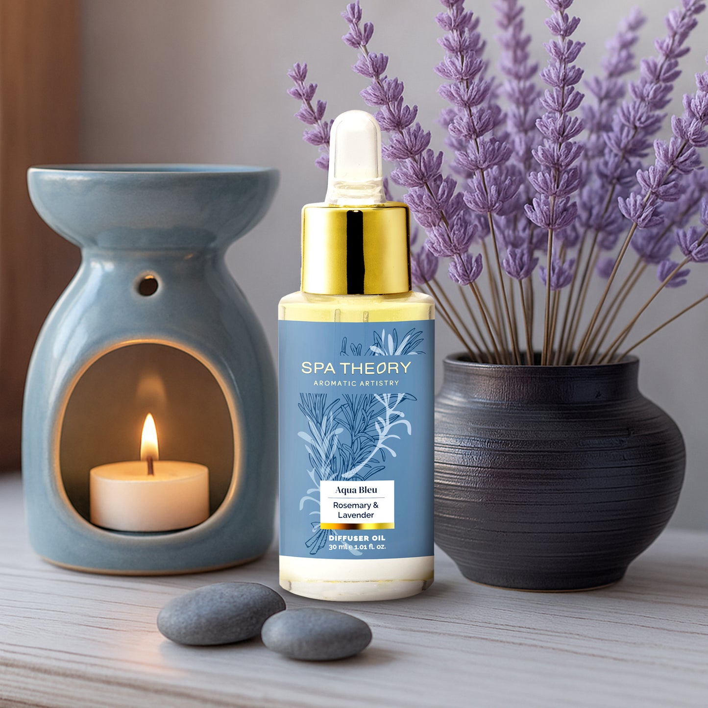 Spa Theory diffuser oil bottle with a candle and lavender plant on a wooden surface