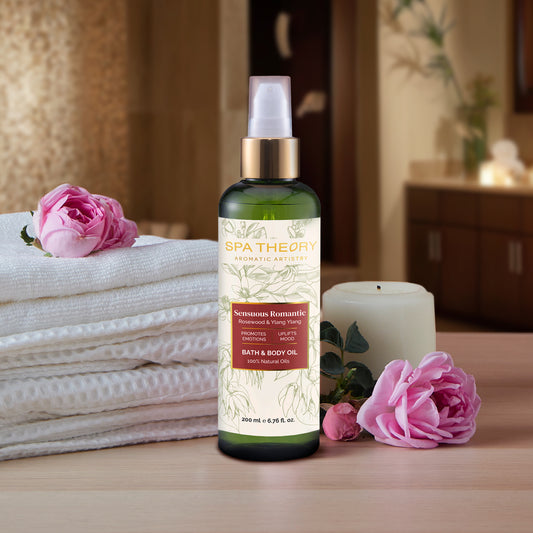 A bottle of ylang ylang massage oil on a wooden surface, surrounded by white towels, pink roses, a candle, and soft lighting, creating a relaxing spa ambiance.